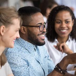2 people looking at a laptop and smiling