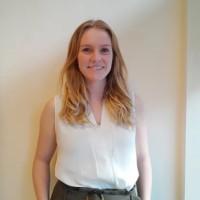 Naomi Smith is standing next to a pale wall she is wearing a white top she has blonde hair 