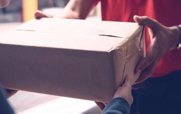 Image shows a parcel being delivered 