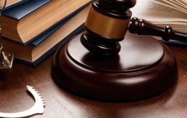 Image shows a gavel and handcuffs