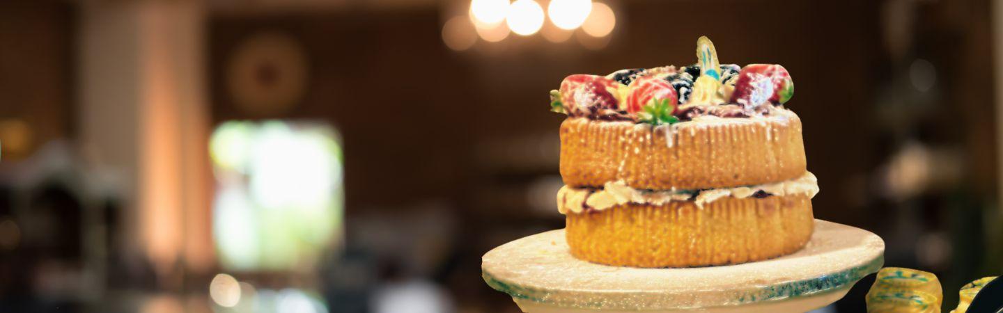 Image shows a victoria sponge cake with neighbourhood watch branding