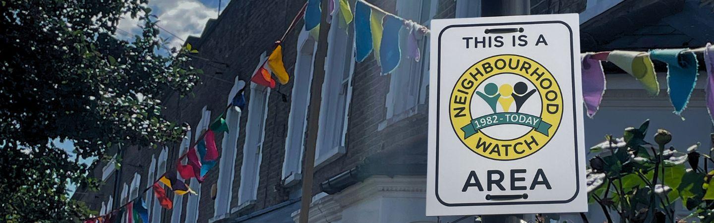 Image shows a street with bunting and a NW sign